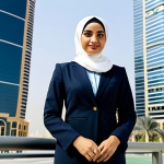 **

"A professional, fully clothed businesswoman wearing a tailored hijab and modest business attire, standing confidently in front of a modern skyscraper in Dubai, UAE. The scene is well-lit, showcasing the city's vibrant atmosphere. Perfect anatomy, correct proportions, natural pose, safe for work, appropriate content, family-friendly, professional photography, high quality."

**